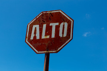 old STOP sign with blue sky