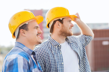 group of smiling builders in hardhats outdoors