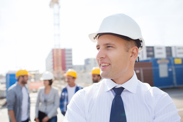 group of smiling builders in hardhats outdoors