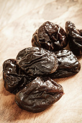 dried plums prunes on wooden table