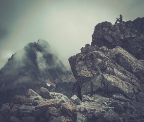 Woman hiker sitting on a mountain peak