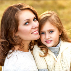 mother and daughter walking in autumn in a field