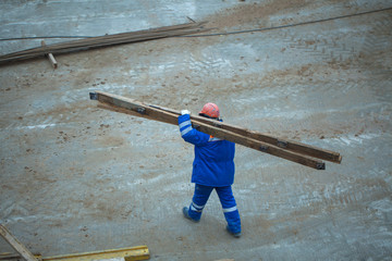 Construction worker carries board