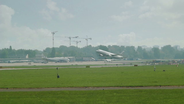 Plane taxiing in distance with another crossing over