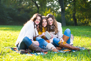 Naklejka na ściany i meble Three beautiful young women in the park
