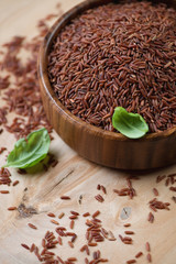 Close-up of red kernel rice over wooden background, studio shot