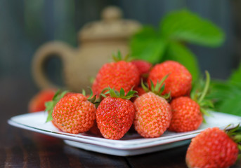 Ripe strawberry on a white plate.