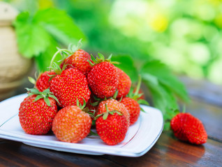 Ripe strawberry on a white plate.