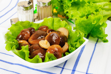 Marinated mushrooms with lettuce leaves.