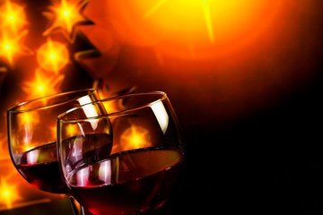 red wine glass against golden lights tree background