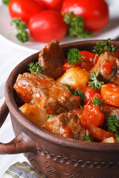 stew in tomato sauce with vegetables in a pot. vertical