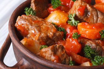 stew in tomato sauce with vegetables and herbs macro. top view