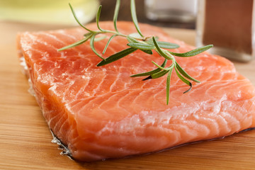 Raw salmon filet on wooden cutting board