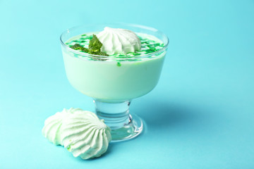 Mint milk dessert in glass bowl on color background
