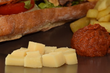 Chicken sandwitch with french fries and sauce.