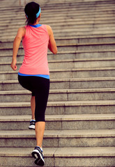 young fitness woman running up on stairs 