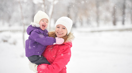 Fototapeta na wymiar happy family mother and baby girl daughter playing in winter
