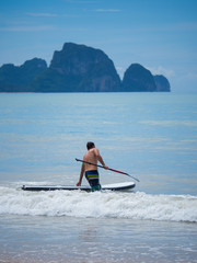 Naklejka premium Man Stand up paddle surfing in Thailand