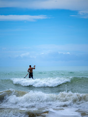 Man Stand up paddle surfing in Thailand