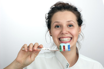 Smiling girl with a green red blue toothbrush