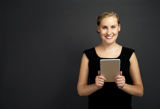 Young Woman Using A Tablet Over Dark Background