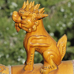 Fototapeta na wymiar antique ceramic figurine on chinese imperial roof - Suan Ni