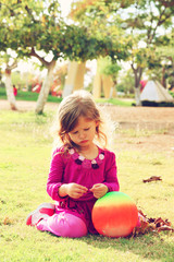 Little lovely girl playing on the grass in the park. filtered im