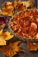 apple pie with cinnamon on the table strewn with autumn leaves