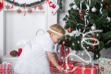 Cute little girl is looking for presents under Christmas New Yea