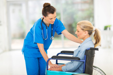 Obraz premium young female doctor comforting disabled senior patient