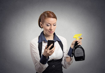 woman holding smartphone and cleaning spray bottle for glass