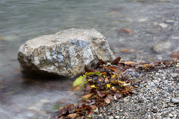 Stone in a lake in autumn with colorful leaves