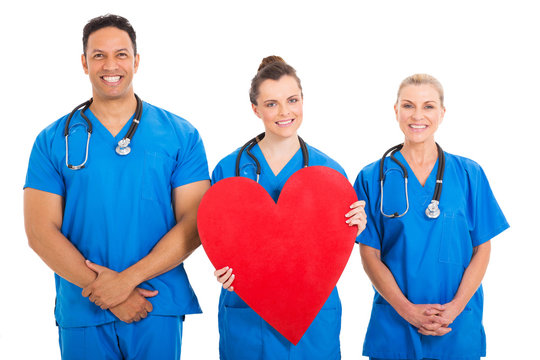 young nurse holding heart shape with colleagues