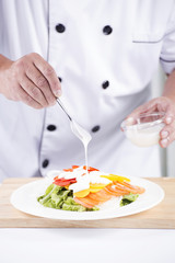Chief putting salad dressing
