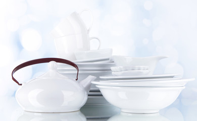 White crockery and kitchen utensils, on light background