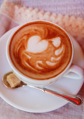 Cup of coffee with cute drawing in cafe