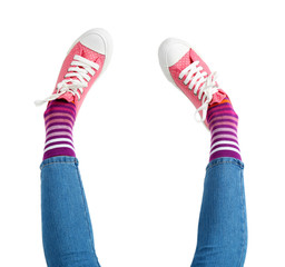 Female legs in colorful socks and sneakers isolated on white