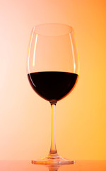Wineglass with red wine on colorful background