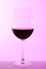 Wineglass with red wine on colorful background