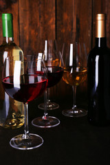 Red wine glass with bottles and glasses of wine close-up