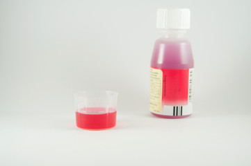 medicine syrup plastic measuring cup and bottle