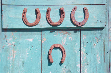 four rusty horseshoe on farm door