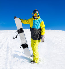 Snowboarder hold snowboard on top of hill