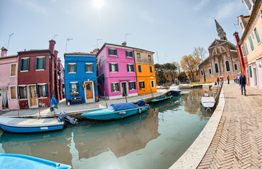 Fototapeta na wymiar BURANO, ITALY - APRIL 8, 2014: Tourists enjoy colourful city bui