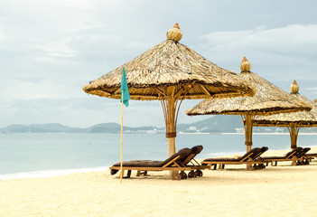 sun loungers with parasols on a beach
