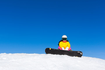 snowboarder woman sitting on snow mountain slope