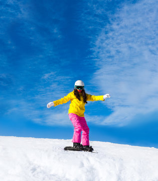 Snowboarder sliding woman down hill, snow mountains