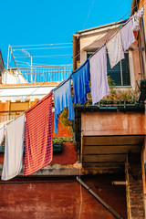 Fototapeta na wymiar Underwear drying on the rope in the old yard in Italy