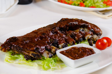 Rack of Saucy Barbecue Pork Ribs on White Plate
