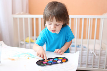 little boy painting with fingers